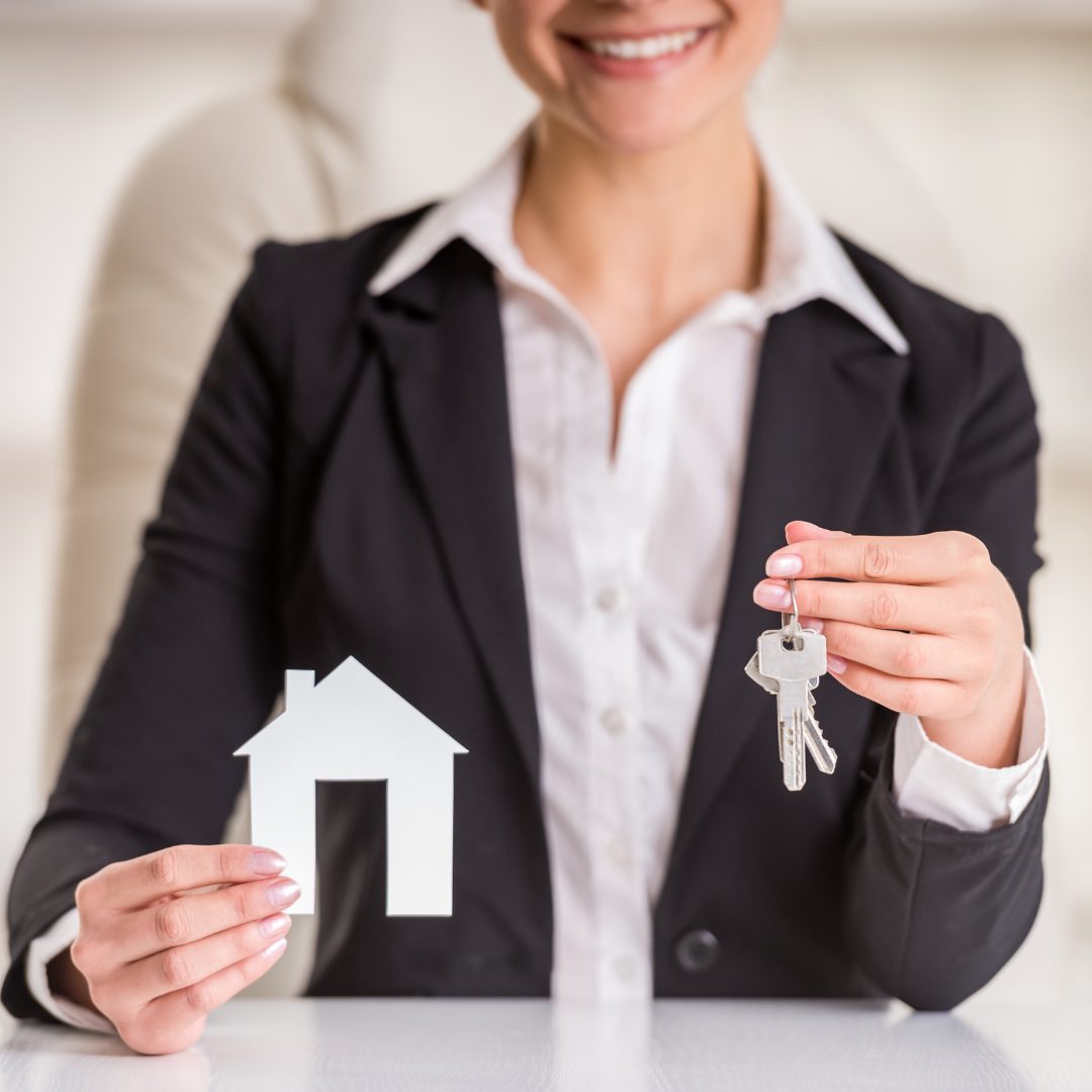 Woman holding paper house and keys